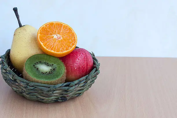 Mixfruit in the basket on plywood background