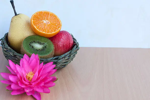 Fresh Mixfruit in the basket on plywood background
