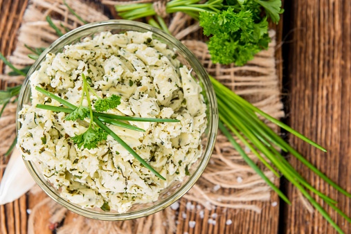 Herb Butter in a small bowl (on wooden background)