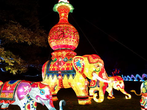 Frome, Somerset, England, UK - December, 6 2014: Seasonal concept photo showing a magical Chinese-style oriental painted / decorated Indian elephants at night. The oriental model was recreated using a wooden frame work covered in coloured canvas / vibrant fabrics and lit by low voltage light bulbs; as part of a display in an oriental Chinese Festival of Lights.