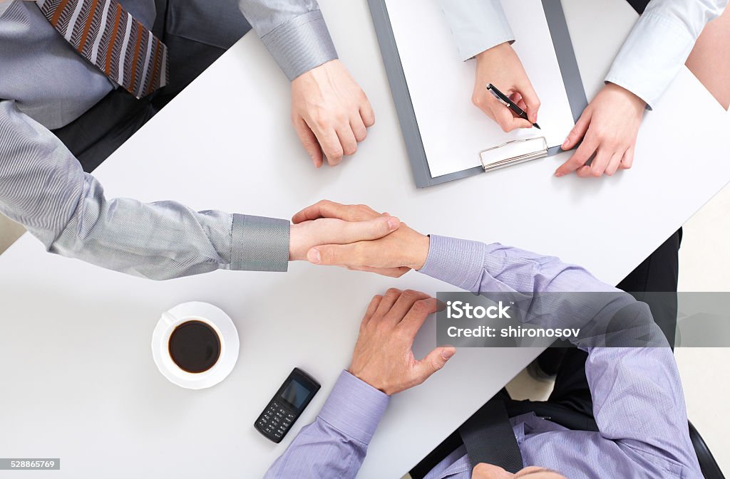 Agreement Above view of businessmen doing agreement at workplace Adult Stock Photo
