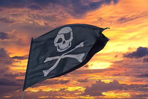istock waving pirate flag jolly roger on sky background 528868737