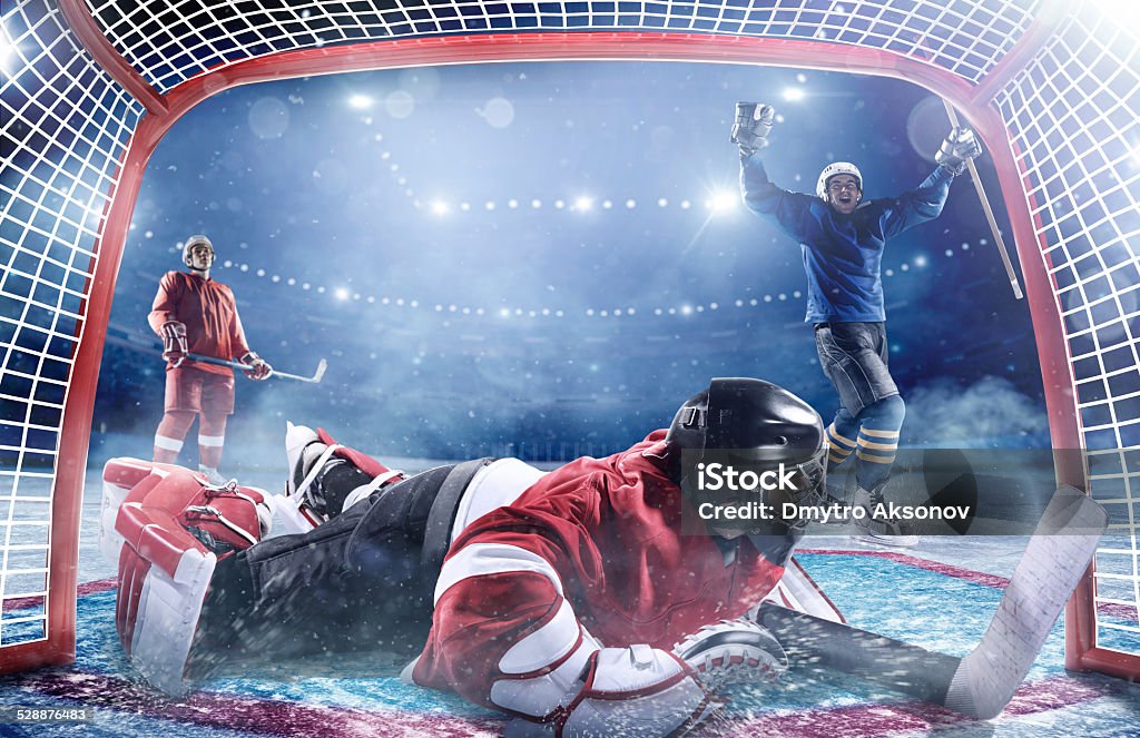 Ice hockey players in action Inside gates view of professional ice hockey player scoring during game in indoor arena full of spectator Activity Stock Photo