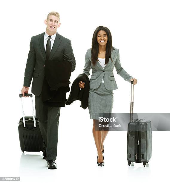 Happy Business Couple Walking Holding Trolley Bag Stock Photo - Download Image Now