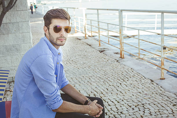 istock Handsome guy sitting on a bench near the river 528887257