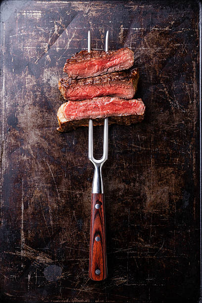 istock Slices of Rare beef steak on meat fork 528888183