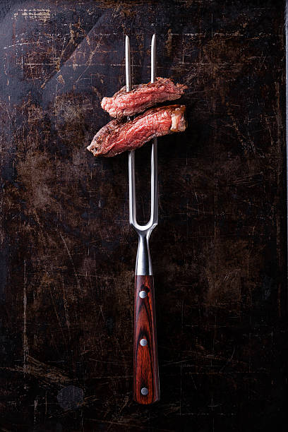 istock Slices of Rare beef steak on meat fork 528888189
