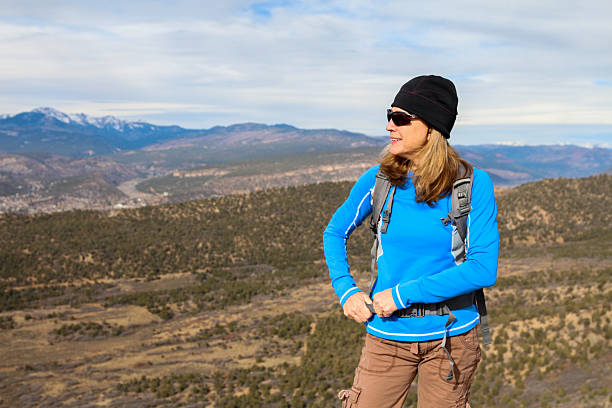 donna regolazione suo spallacci - mountain peak long colorado mountain foto e immagini stock