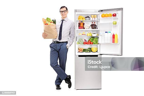 Man Holding Grocery Bag And Leaning On A Fridge Stock Photo - Download Image Now - 20-29 Years, Adult, Adults Only