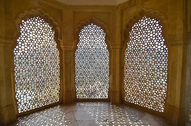 Jaipur, Rajasthan state, India - Amer Fort (Amber Fort) 3 windows made by stone, with beautiful pattern. Outside the window it is the Lake Maota just beside the fort.