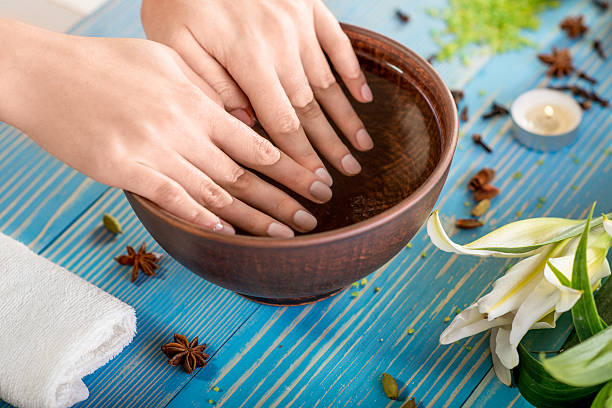 Finger nails care Soaking finger nails in the bath with water on wooden table with spa stuff on background cuticle photos stock pictures, royalty-free photos & images