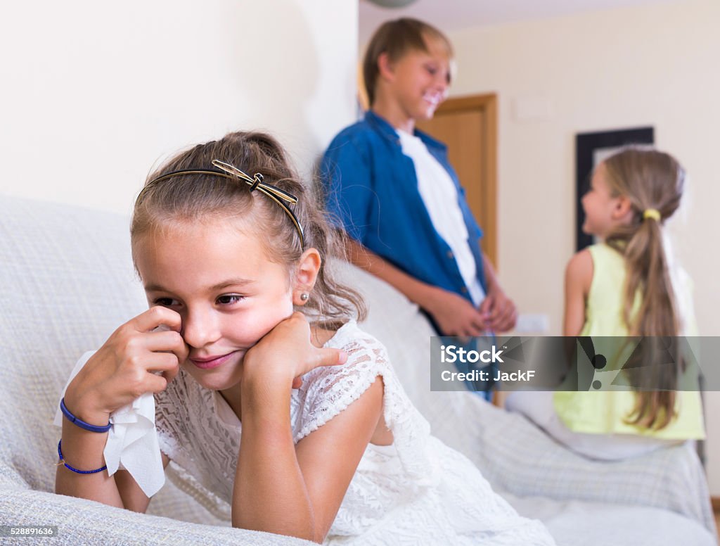 First amorousness:  girl and couple of kids apart First amorousness: unhappy girl and couple of kids apart indoors Apartment Stock Photo