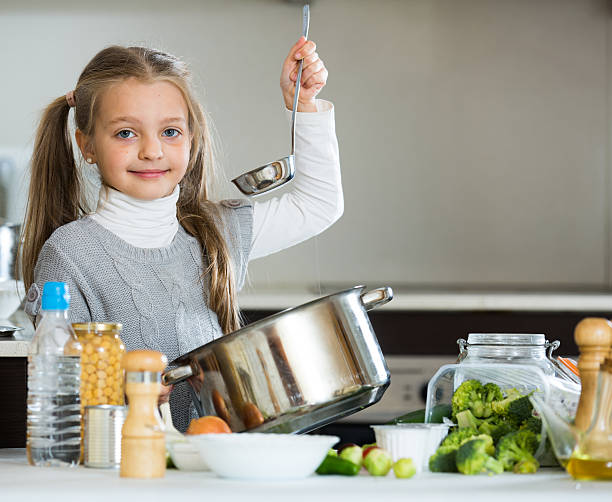 istock Smiling little girl learning to cook in kitchen 528892622