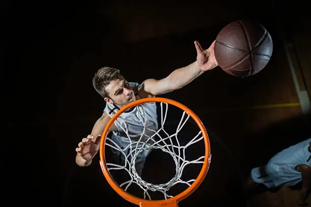 Professional basketball player penetrating to the basket and scoring a basket with a lay up.   