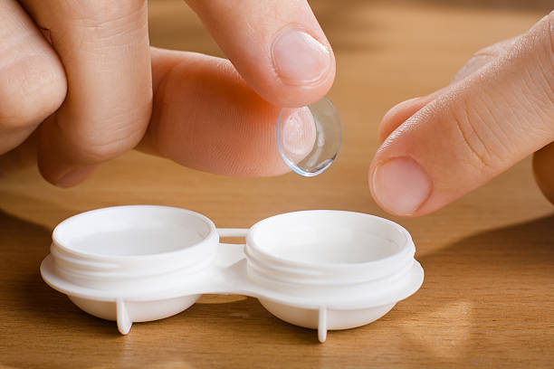 istock hand with contact lens, closeup 528902592