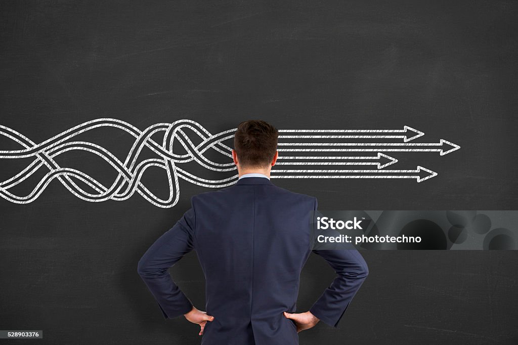 BusinessThinking about structuring business process and solutions Businessman is standing in front of blackboard with drawn arrows. Thinking about structuring business process and solutions. Order Stock Photo