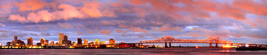 New Orleans downtown skyline along the banks of the Mississippi River at night. New Orleans is a major United States port and the largest city in Louisiana. New Orleans is known for its famous Creole food, unique architecture, music, nearby swamps and plantations and all-around mysticism