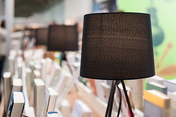 istock Electric brown table reading lamp and books in a library 528904252