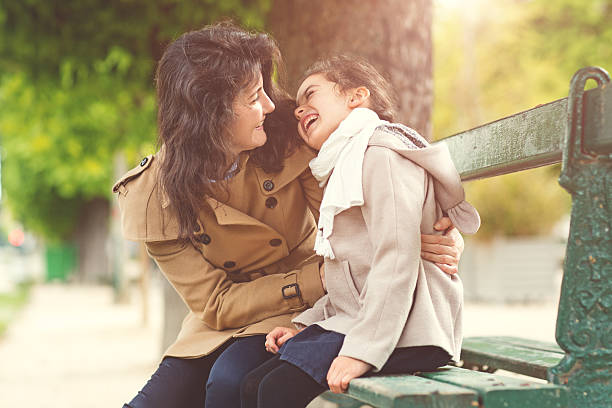 Brunette mother daughter hugging in Paris park on spring afternoon Brunette mother daughter hugging in Paris park on spring afternoon divorcee stock pictures, royalty-free photos & images