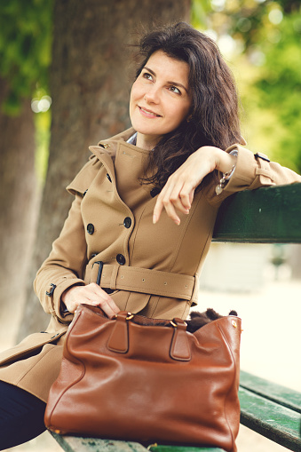 Beautiful brunette woman sitting in Paris gardens