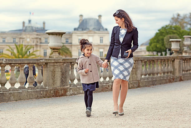 Brunette mother daughter walking in Paris park on spring afternoon Brunette mother daughter walking in Paris park on spring afternoon divorcee stock pictures, royalty-free photos & images
