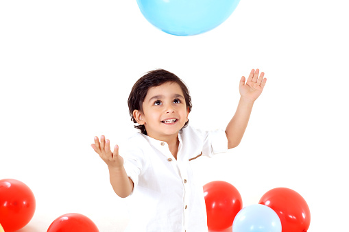 happy little boy playing on white background