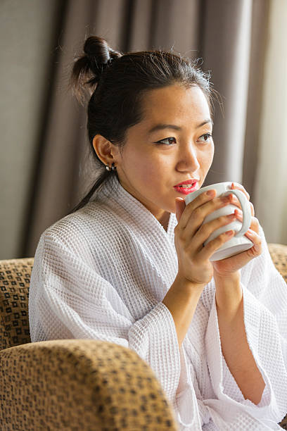 istock Robe Wearing Young Asian Woman With Coffee or Tea 528909392