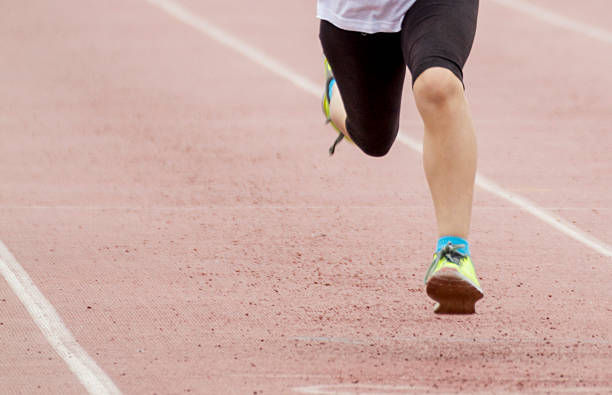 running competition Legs moving during a sports competition of racing. womens track stock pictures, royalty-free photos & images