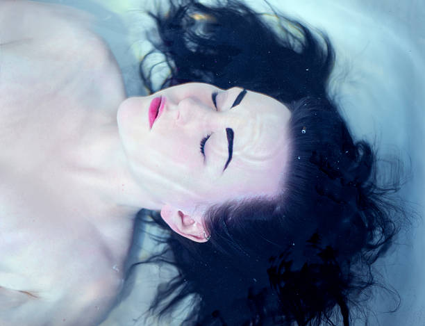 istock woman submerging herself underwater in her bathtub 528910586