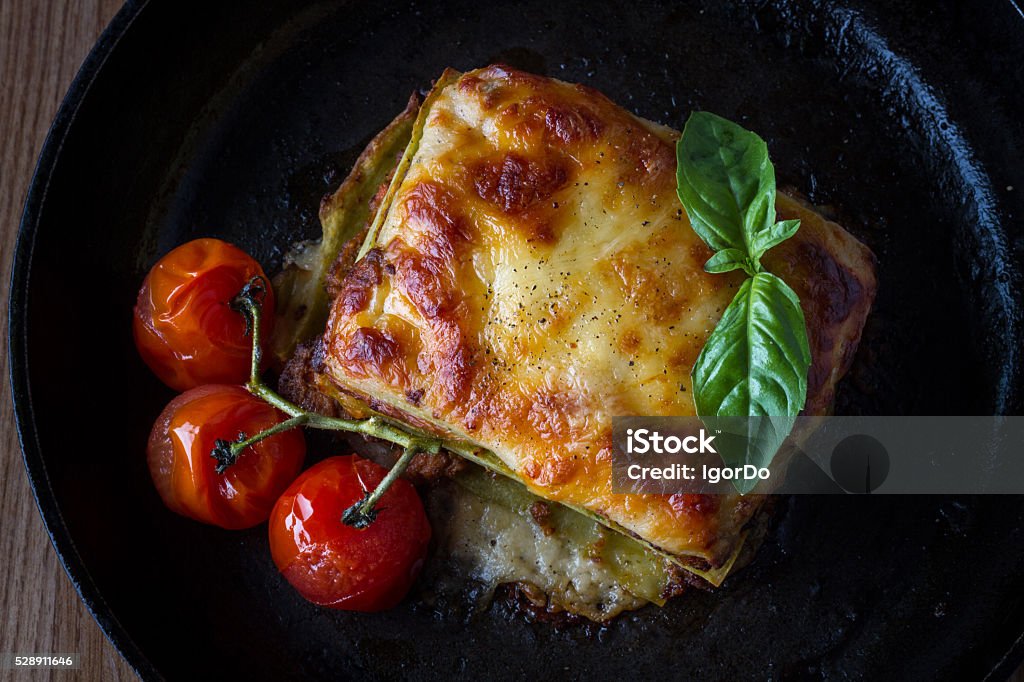 Lasagna with grilled tomatoes Lasagna with grilled tomatoes on black cast iron plate Baked Stock Photo
