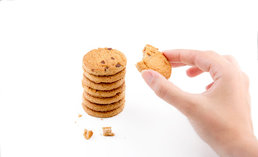 Bitten cookie in woman hand with isolated white background
