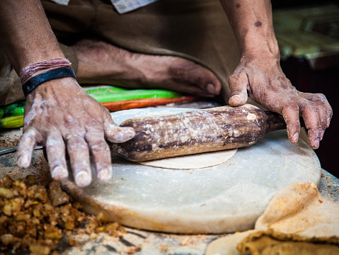 On an Old Delhi street, an Indian man is making parathas, which are unleavened flat breads cooked in glee (clarified butter) or oil. The dough is often stuffed with all kinds of ingredients. Very popular for breakfast in some regions of India.