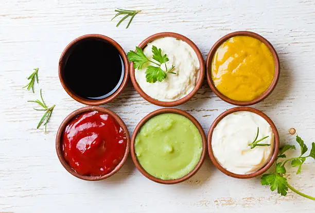 Photo of Sauces ketchup, mustar, mayonnaise, wasabi, soy sauce in clay bowls