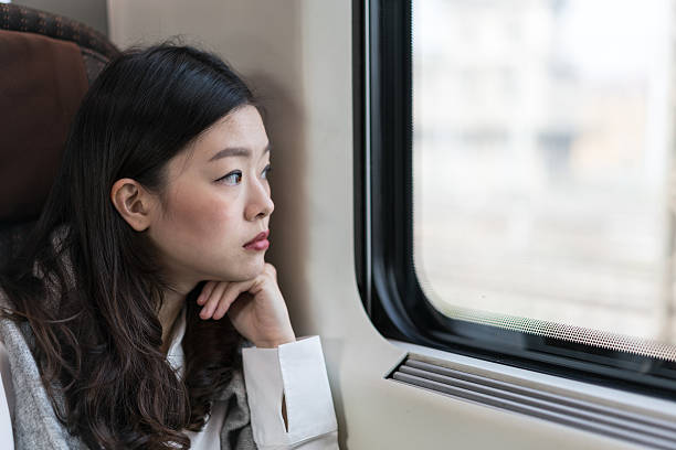 istock Beautiful asian woman looking through train window, with copy space 528919820