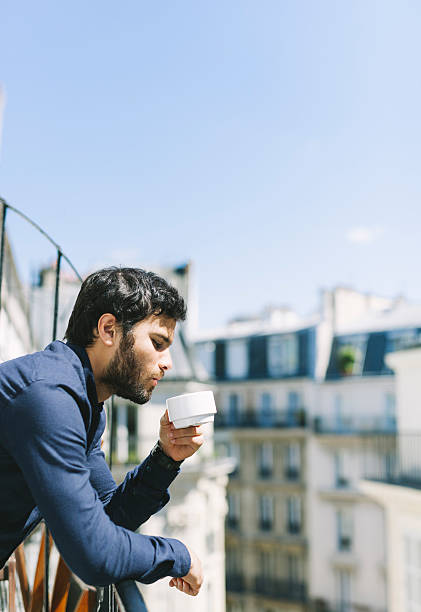 istock Handsome Young Man Drinking Coffee on a Sunny Balcony 528921826
