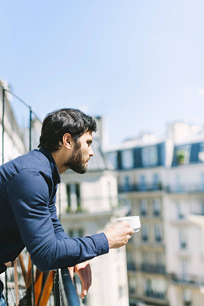 istock Man Relaxing with a Cup of Coffee on a Balcony 528922194