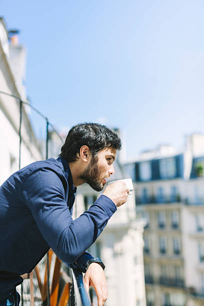 istock Handsome Man Sipping Coffee in a Sunlit Balcony 528922262