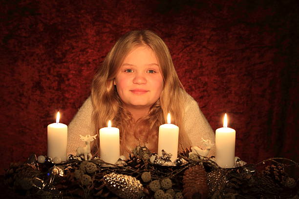 istock young blond girl with Advent wreath 528927413