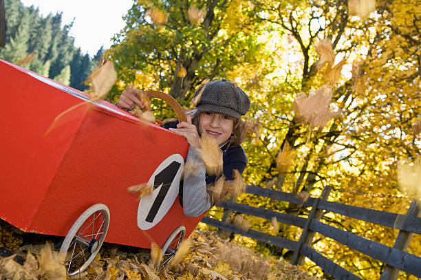 Austria, Salzburger Land, Boy  sitting in soapbox car, smiling