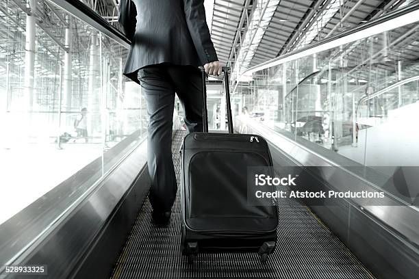 Businessman Holding Trolley Bag Going Up On The Escalator Stock Photo - Download Image Now