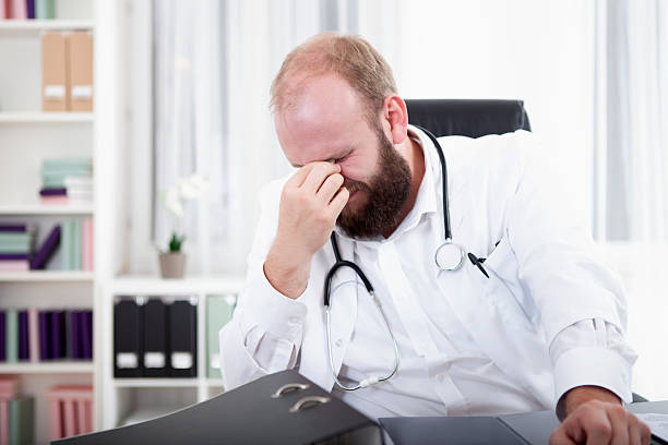 istock Doctor is overworked and sits at his desk in his practice 528954363