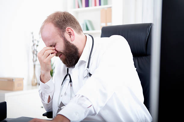 istock Doctor is overworked and sits at his desk in his practice 528954365