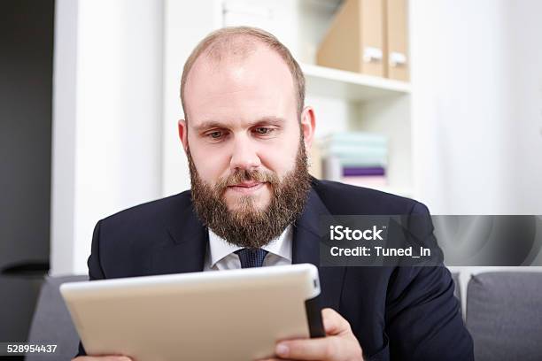 Businessman Reads Something On His Tablet Computer Stock Photo - Download Image Now - Adult, Adults Only, BART