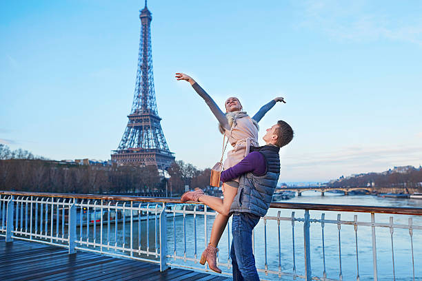 романтическая пара возле эйфелевой башни в париже, франция - honeymoon wedding paris france bride стоковые фото и изображения