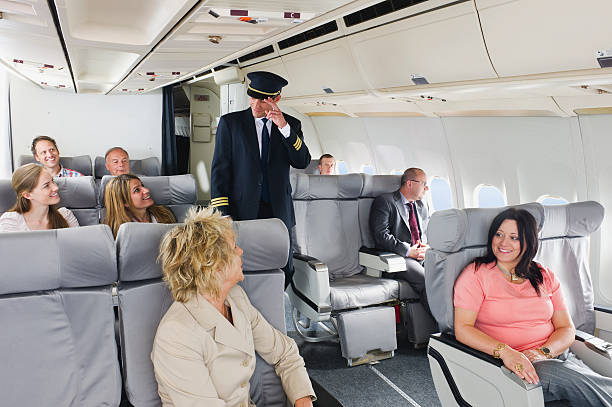 istock Flight captain standing in between passengers of business class airplane 528955773