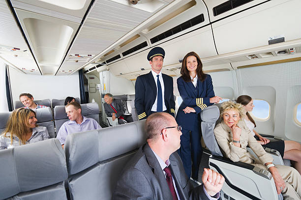 istock Flight captain and stewardess standing in between passengers, business class 528955777