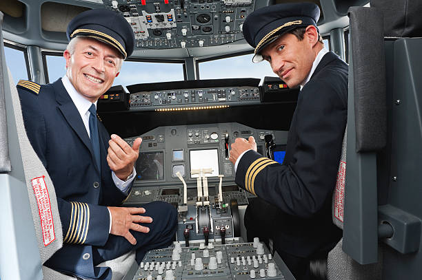 piloto y copiloto pilotar avión de pasajeros cabina de piloto - pilot cockpit flying business fotografías e imágenes de stock