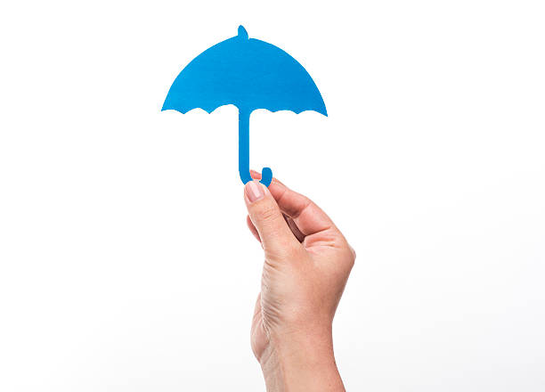 istock Hand holding a paper umbrella on white background, protection concept 528956986