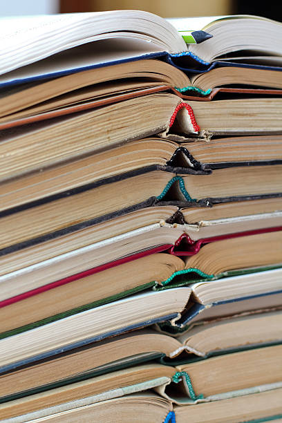 istock stack of opened old books and a pencil, vertical 528957588