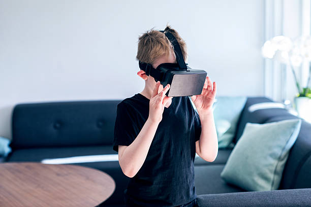 gafas de realidad virtual se ajusta mediante un niño - video game child handheld video game little boys fotografías e imágenes de stock